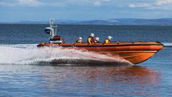 Kinghorn inshore B class lifeboat cruises along the water on a bright sunny day