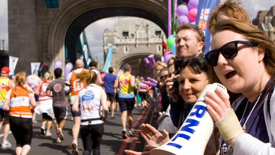 RNLI supporters cheering on marathon runners at Tower Bridge, London