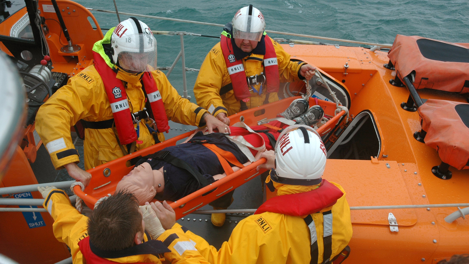 RNLI crew members training with their casualty manikin 