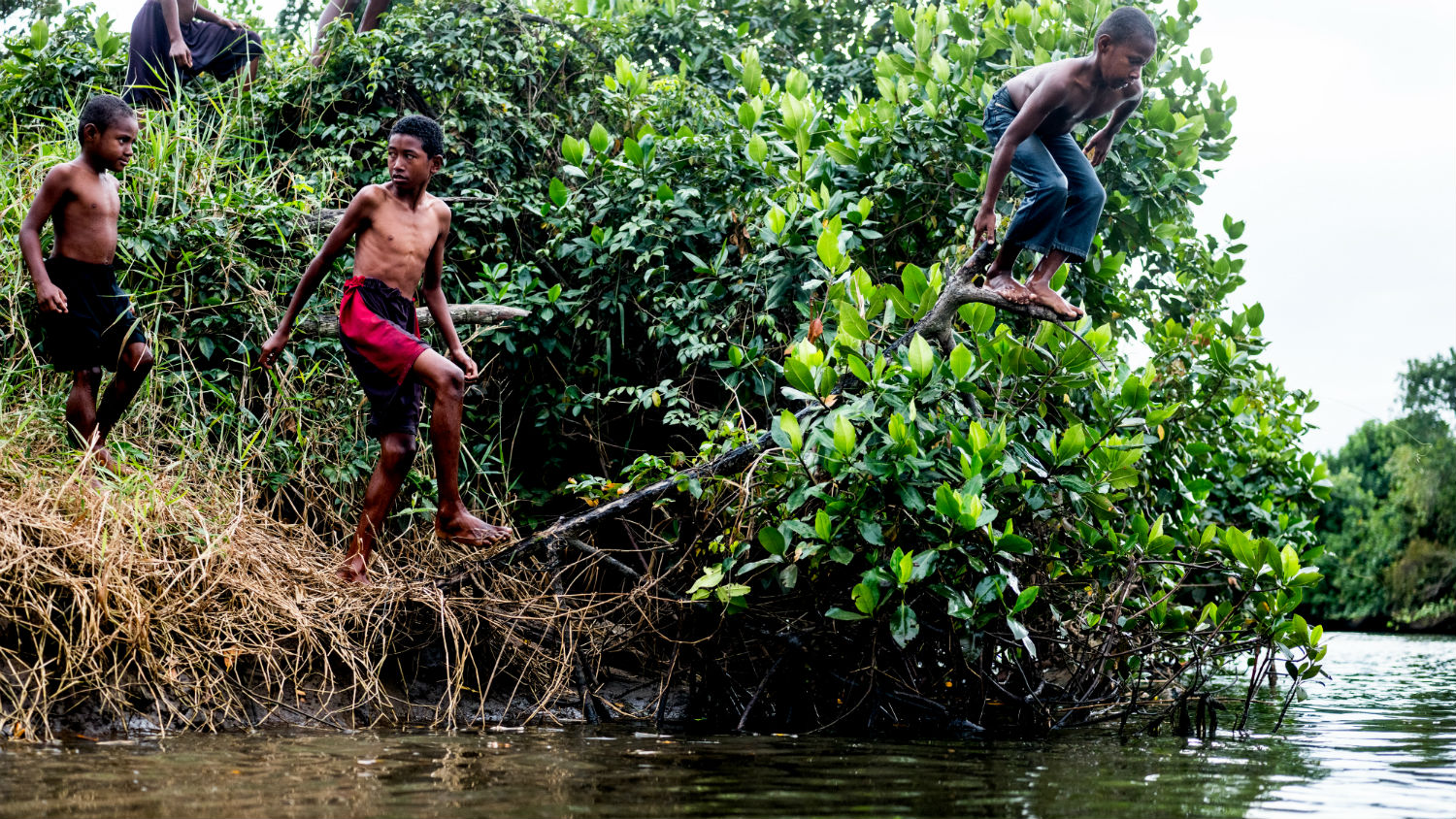 Children prepare to jump into a river in Nadi, Fiji