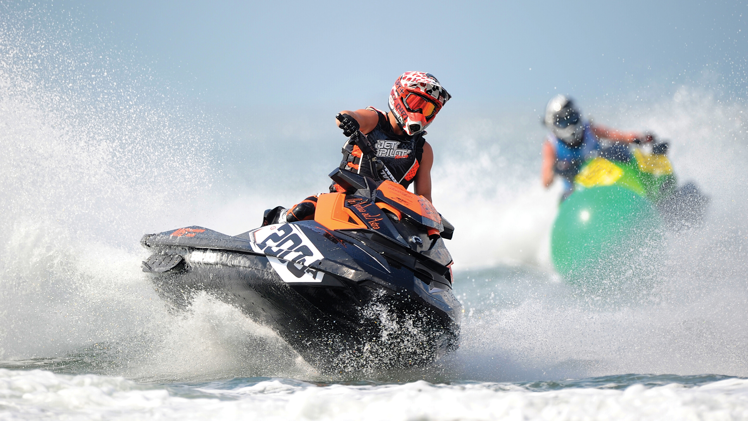Two people racing personal watercraft