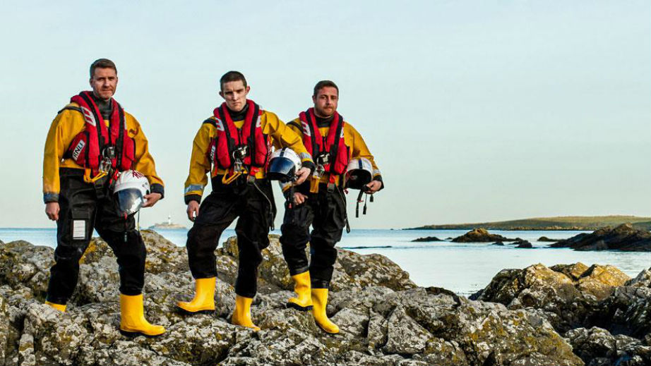 Skerries RNLI lifeboat crew on the shore with Colt Island in the background