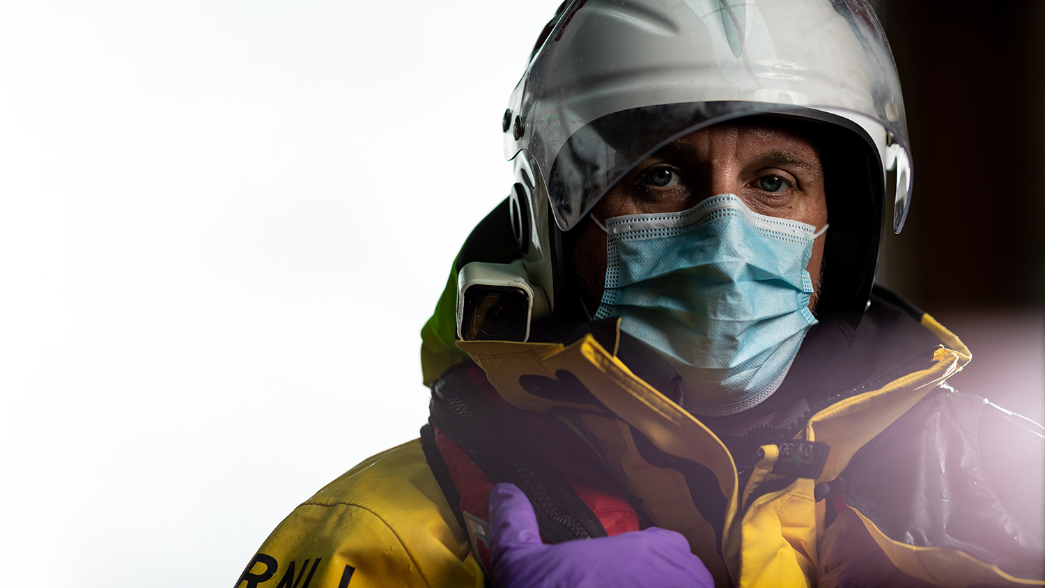 A crew member wearing a disposable face mask and gloves