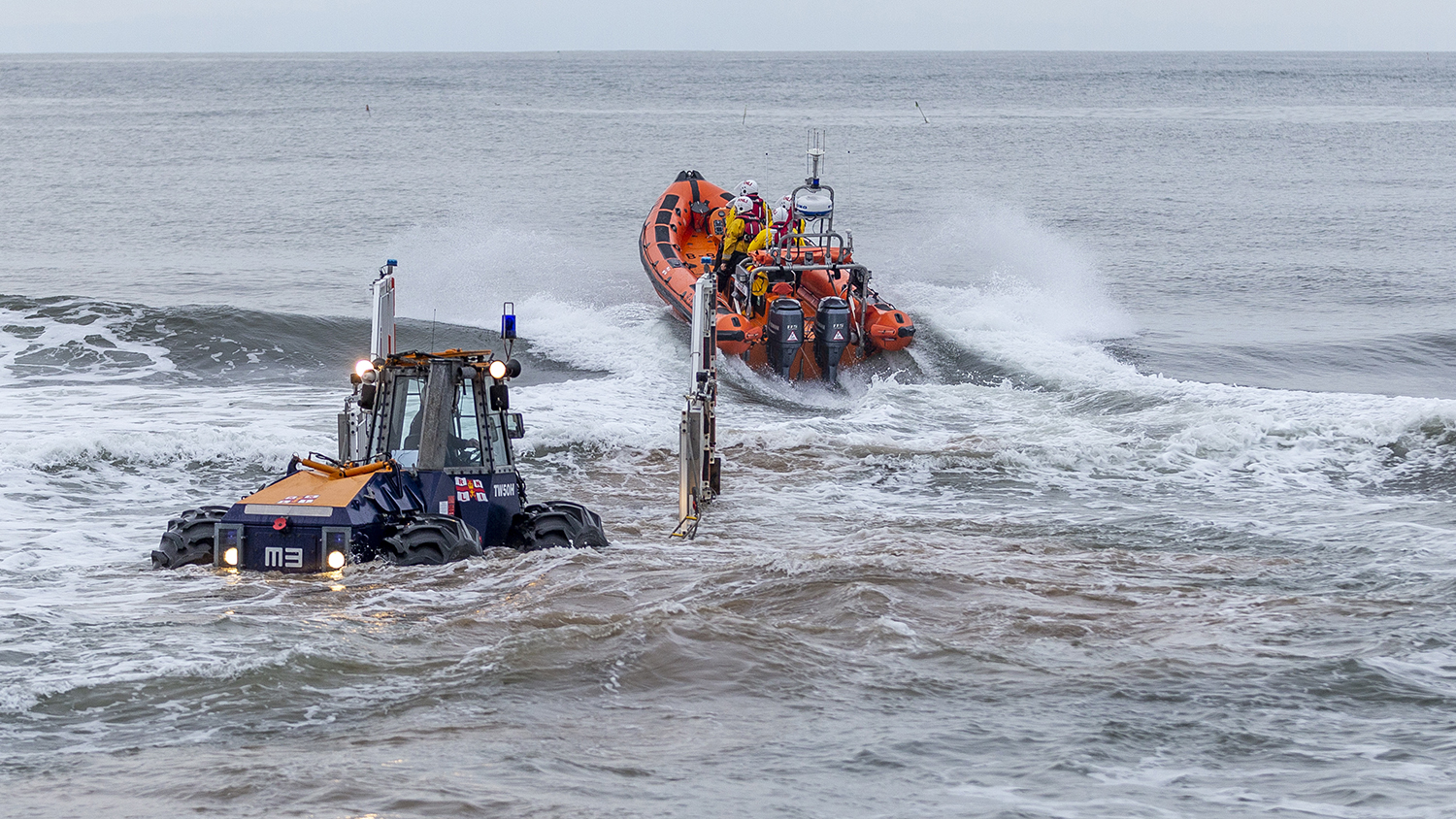 Redcar volunteers launch into the surf from their lifeboat carriage