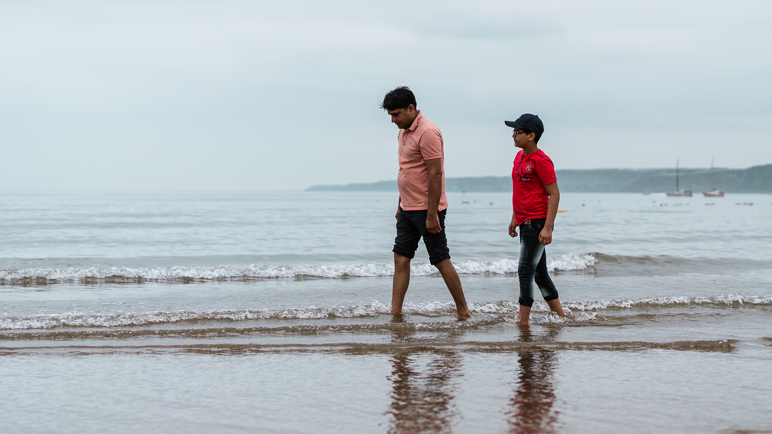 Ravi and his father Nathu walking along the beach in Scarborough