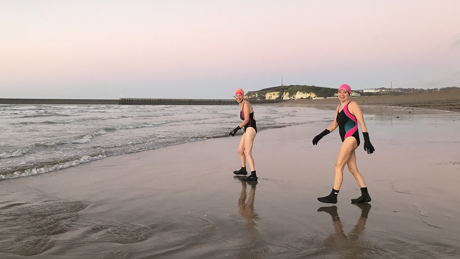 Two Mermaids in their swimming costumes, neoprene socks and gloves, and swimming caps