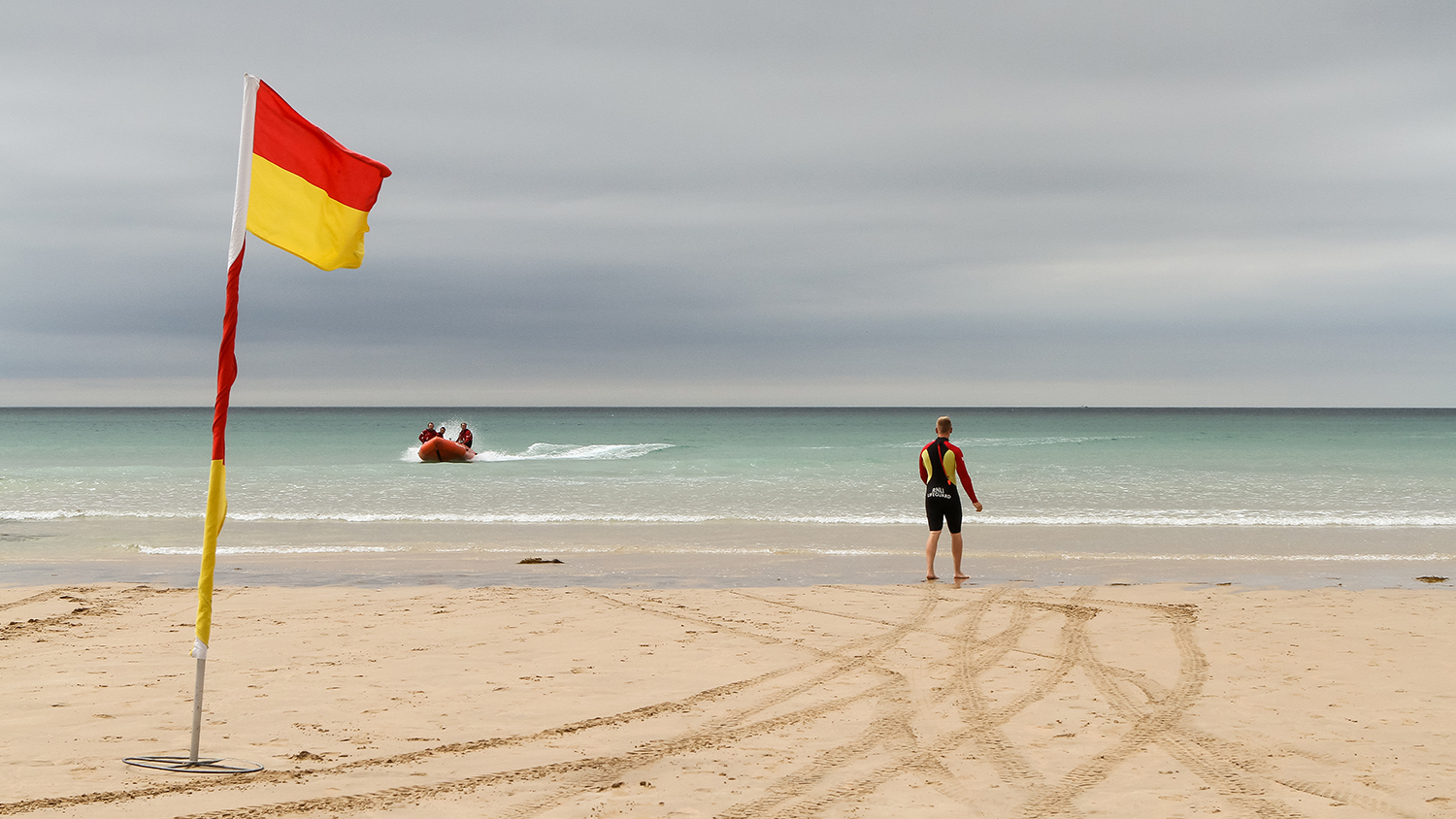 Lifeguards on the beach, looking out to sea