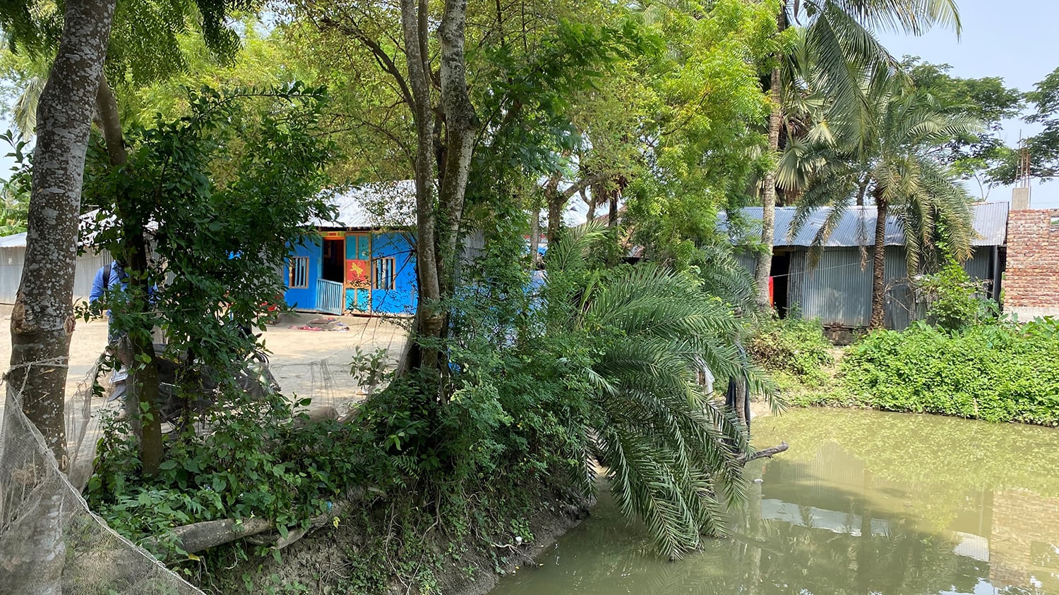 A deep pond just metres from the Anchal, with white netting around the outside