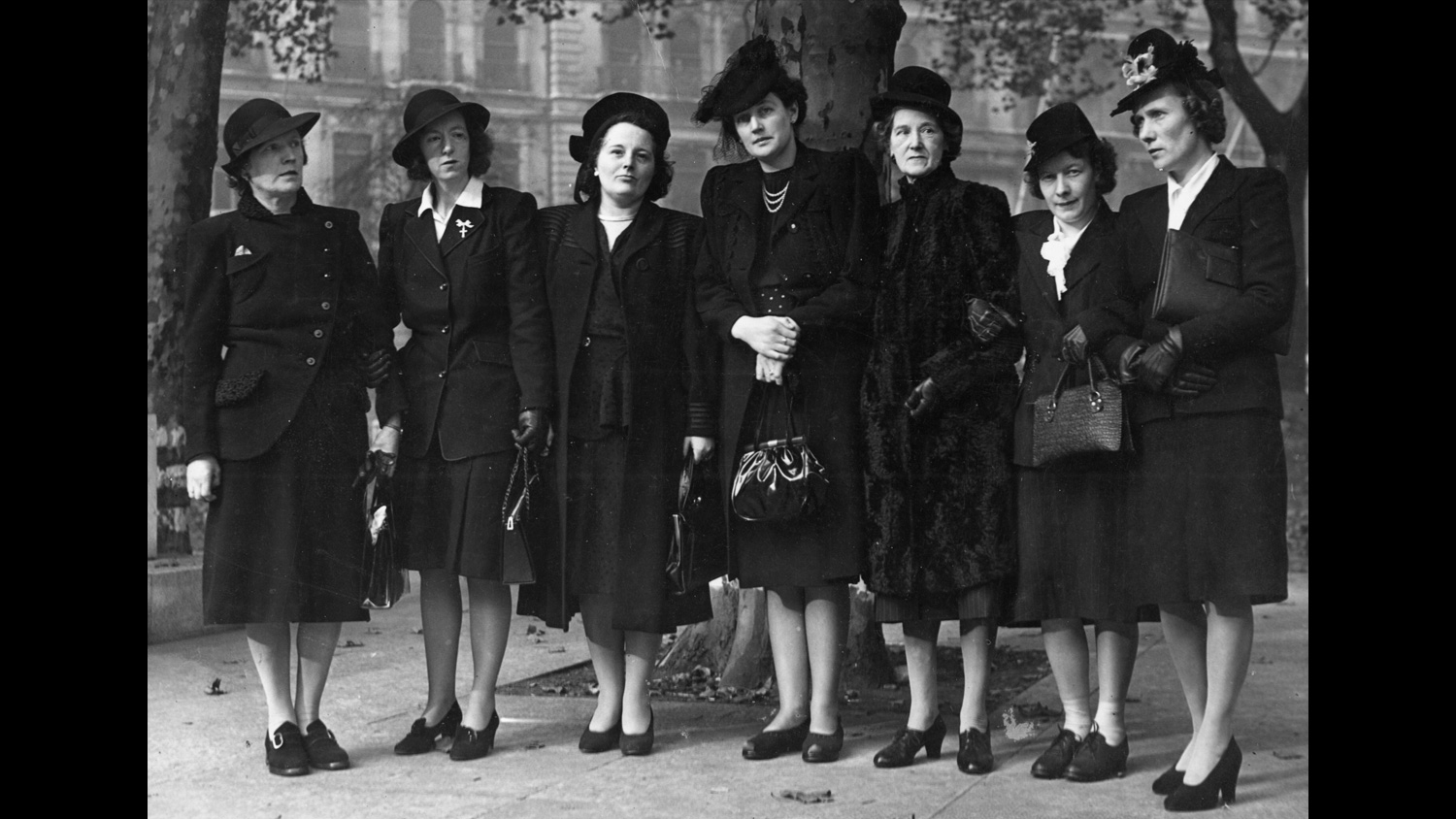 Black and white photo of seven women dressed in black