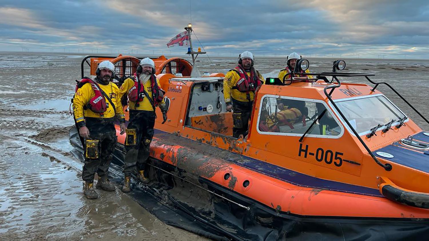 Four crew members stand with Hoylake’s hovercraft, Hurley Spirit  
