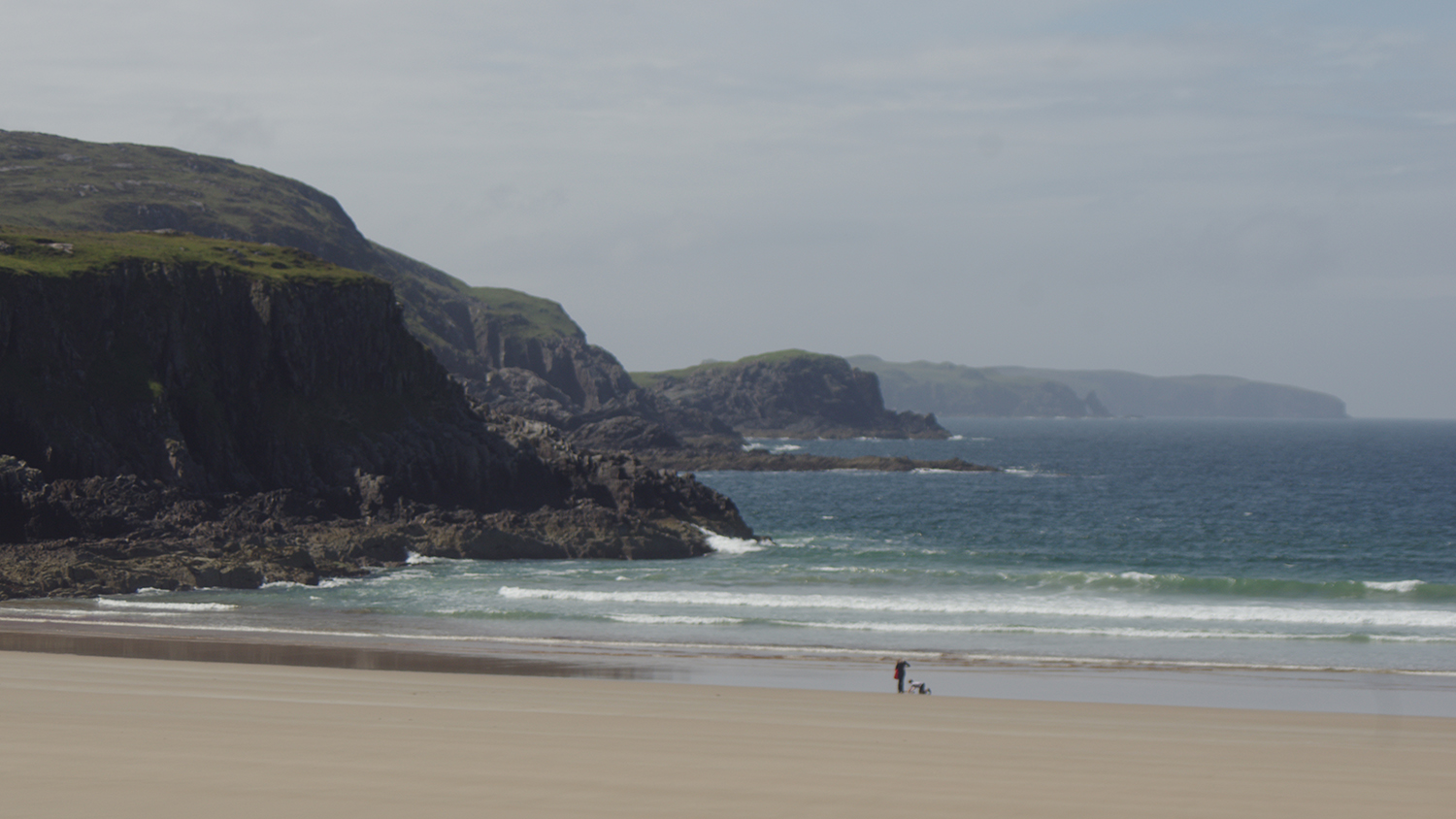 Small waves roll into the rock-framed Farr Bay in the Scottish Highlands