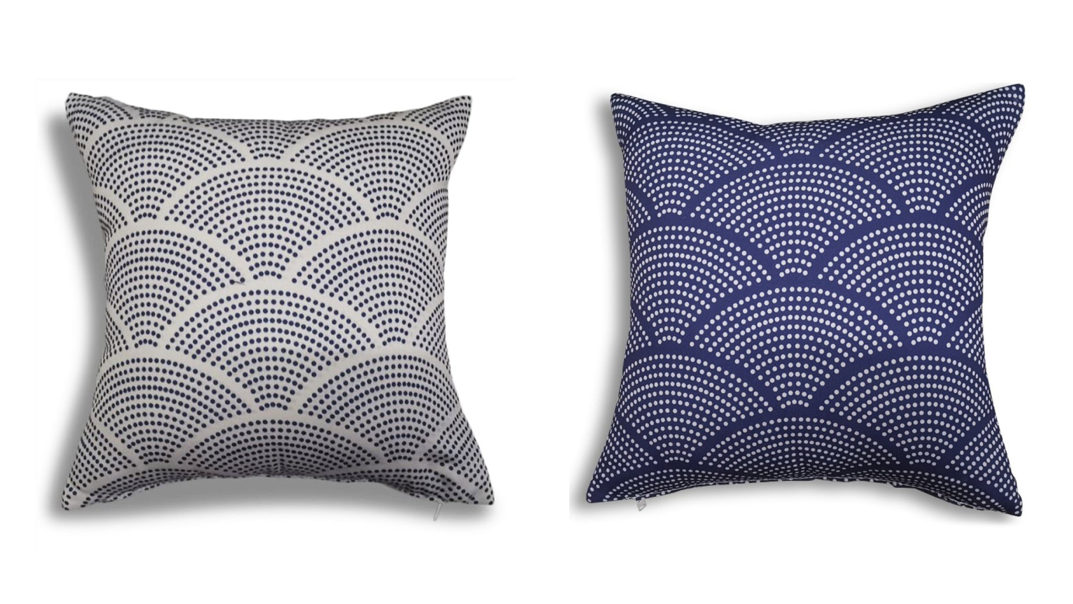 A cushion patterned with radiating and overlapping dotted circles that resemble stylised fish scales. Shown twice: blue dots on white and white dots on blue.