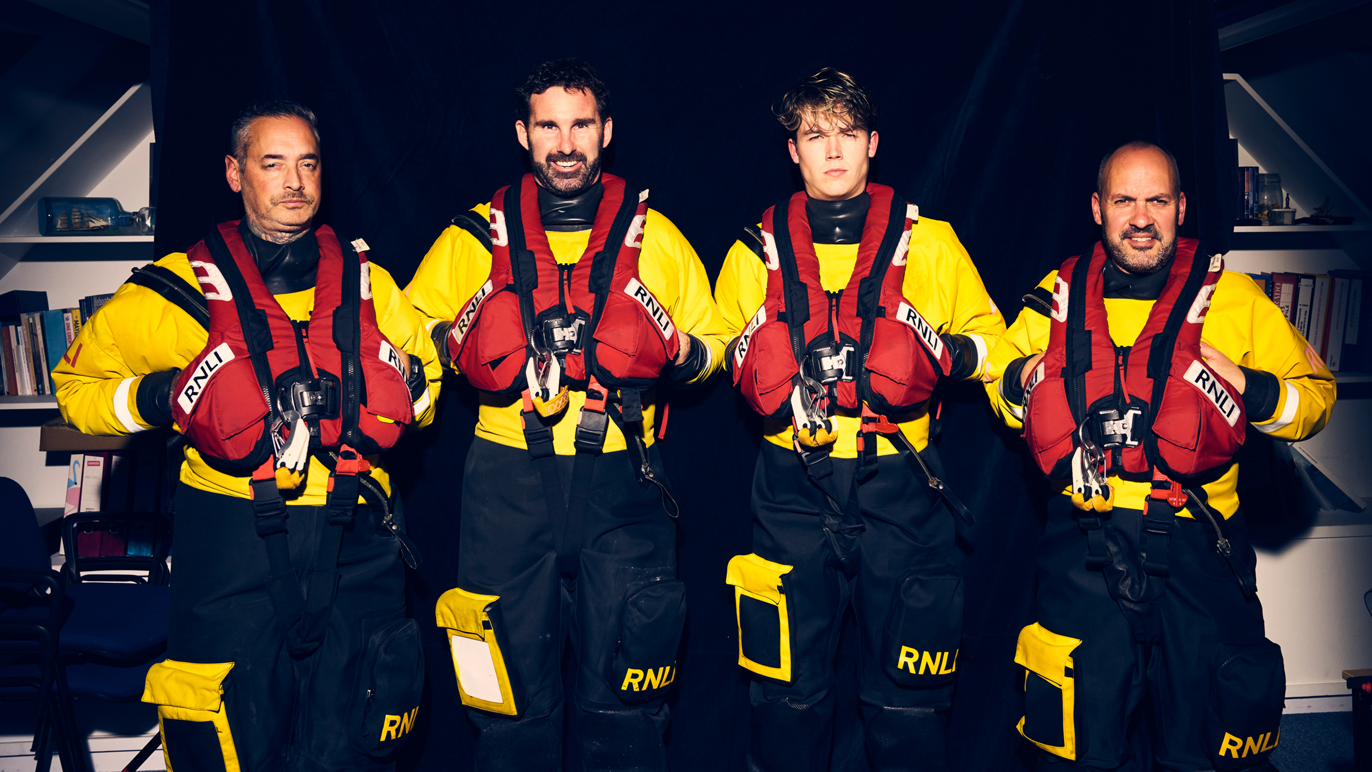 Four RNLI crew members from Great Yarmouth and Gorleston Lifeboat Station standing in a row. 