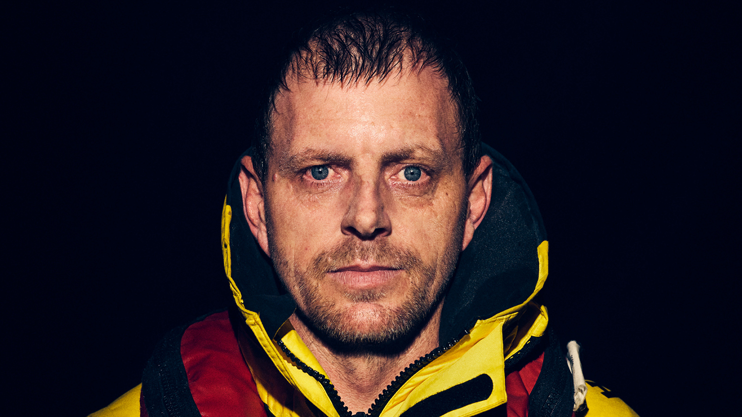 Great Yarmouth and Gorleston Coxswain Andy Mason, looking directly at the camera with a dark background.