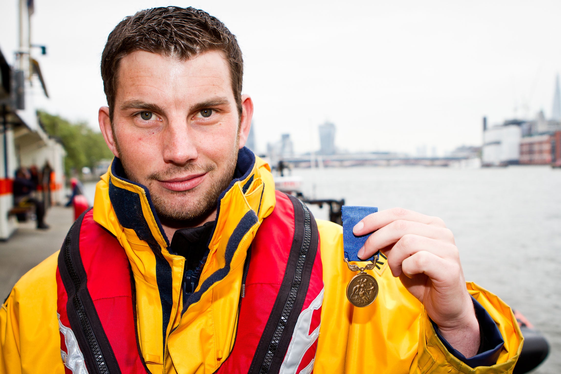 Porthcawl Lifeboat Station’s Chris Missen, holding up his Bronze Medal for Gallantry 