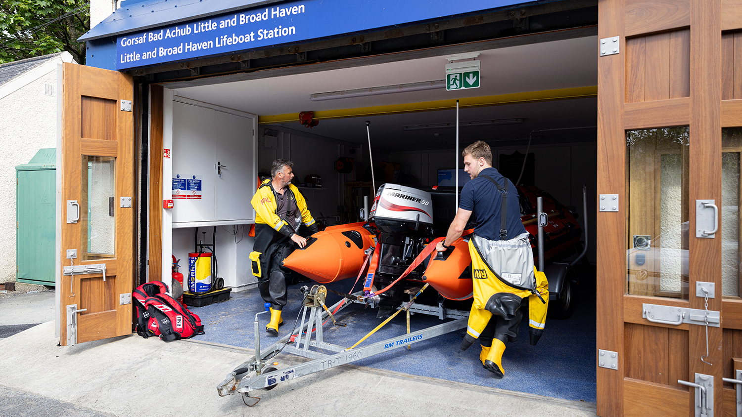 Two crew members from Little and Broad Haven RNLI get their D class lifeboat ready.