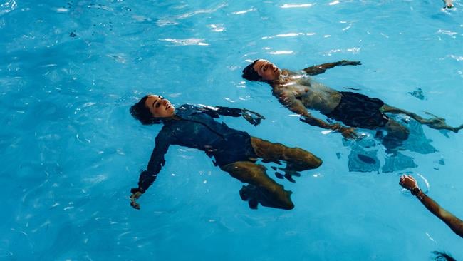 Two people floating in the water in the RNLI's Sea Survival pool.