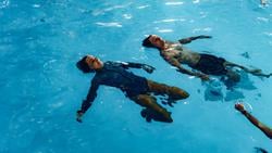 Two people floating in the water in the RNLI's Sea Survival pool.