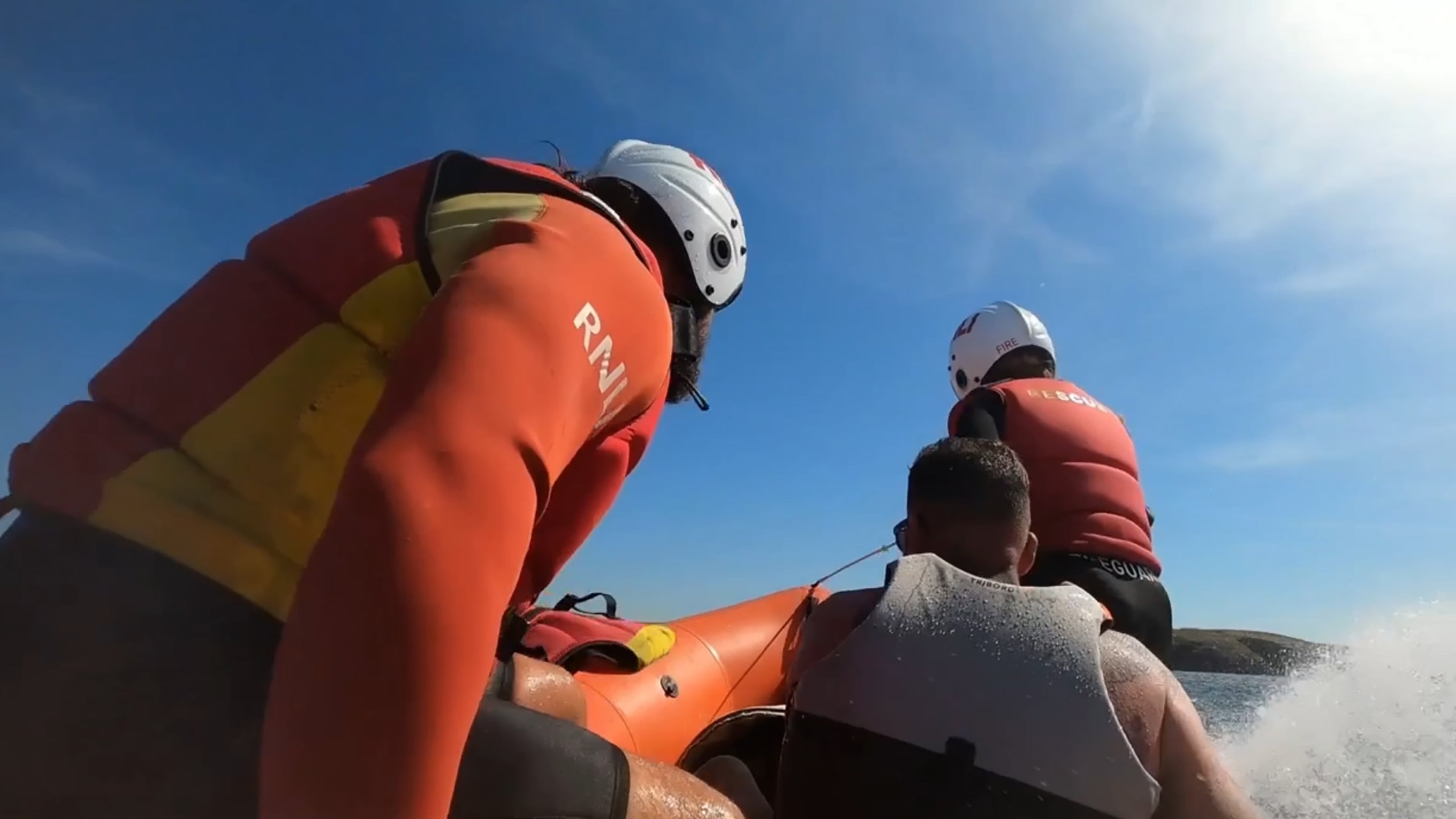 Andy sits in an inshore rescue boat, along with two RNLI lifeguards. Photo: RNLI.