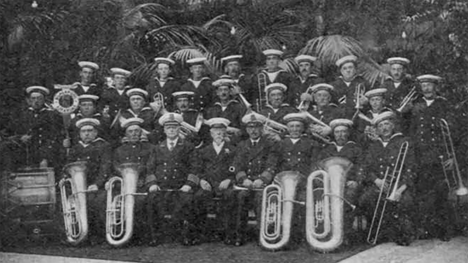 A black and white photograph from an old issue of the Lifeboat magazine of the Blackpool Life-boat Band, who are sitting together, holding their instruments.