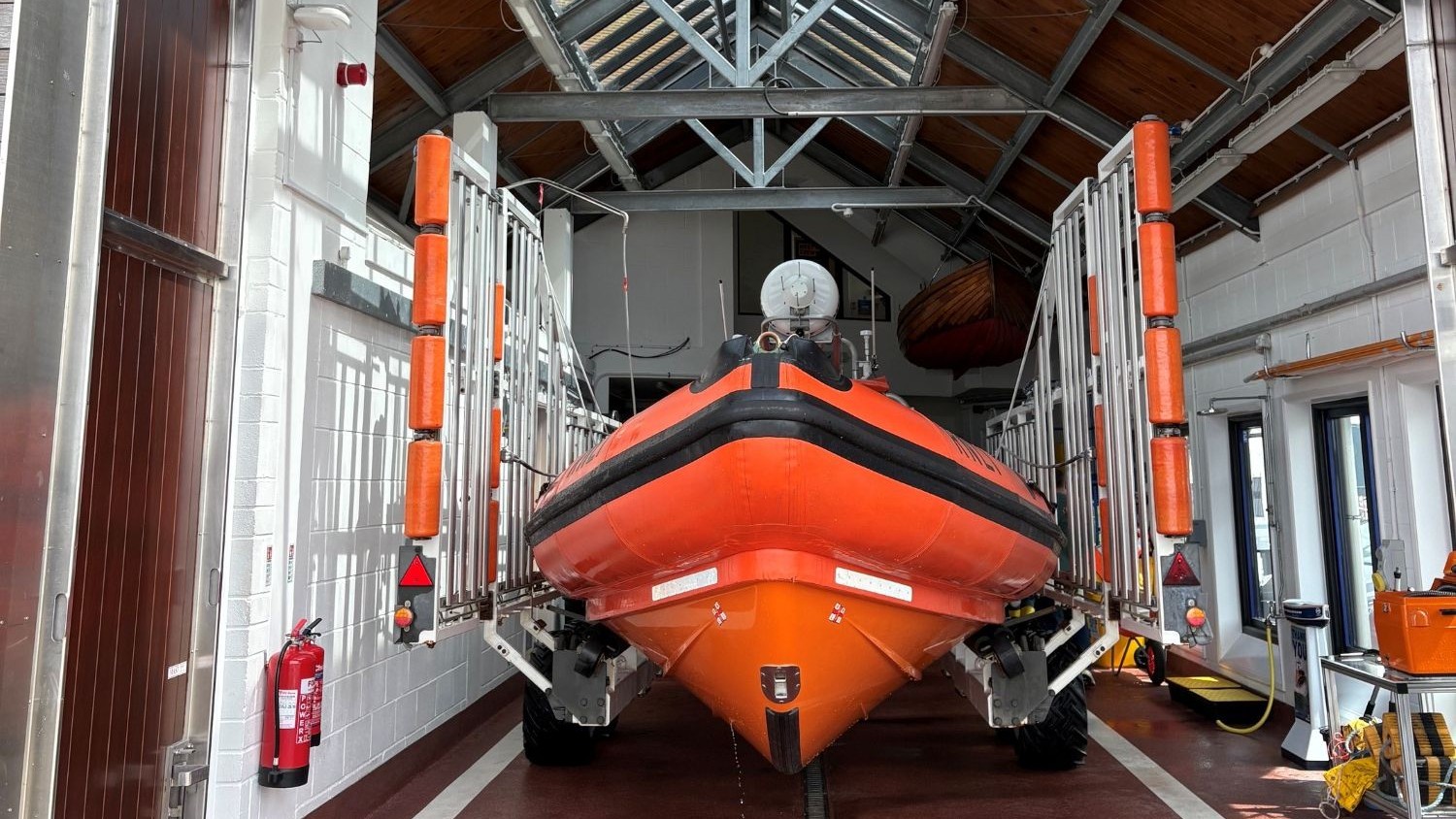 Atlantic 85 on a rig inside a boatshed pointing out the open doors.