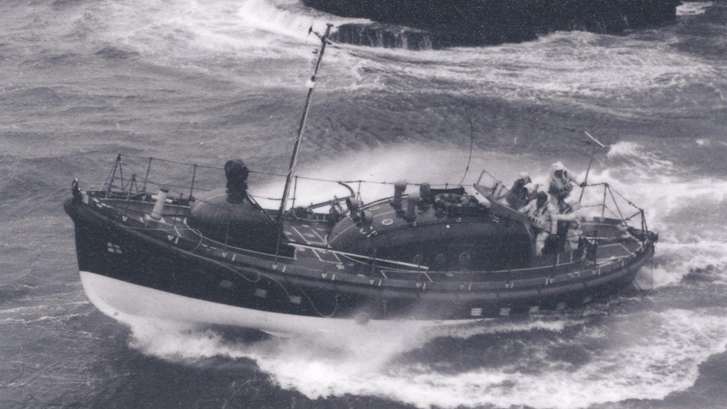 A black and white photograph of Whitby’s lifeboat Mary Ann Hepworth at sea, with its crew onboard.