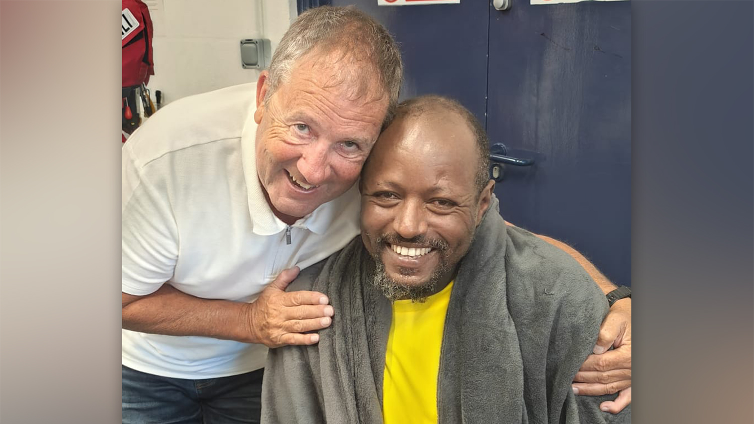 Rescuee Samuel Kassu with RNLI Shore Crew Volunteer Bob Morgan, pictured after Samuel was rescued.