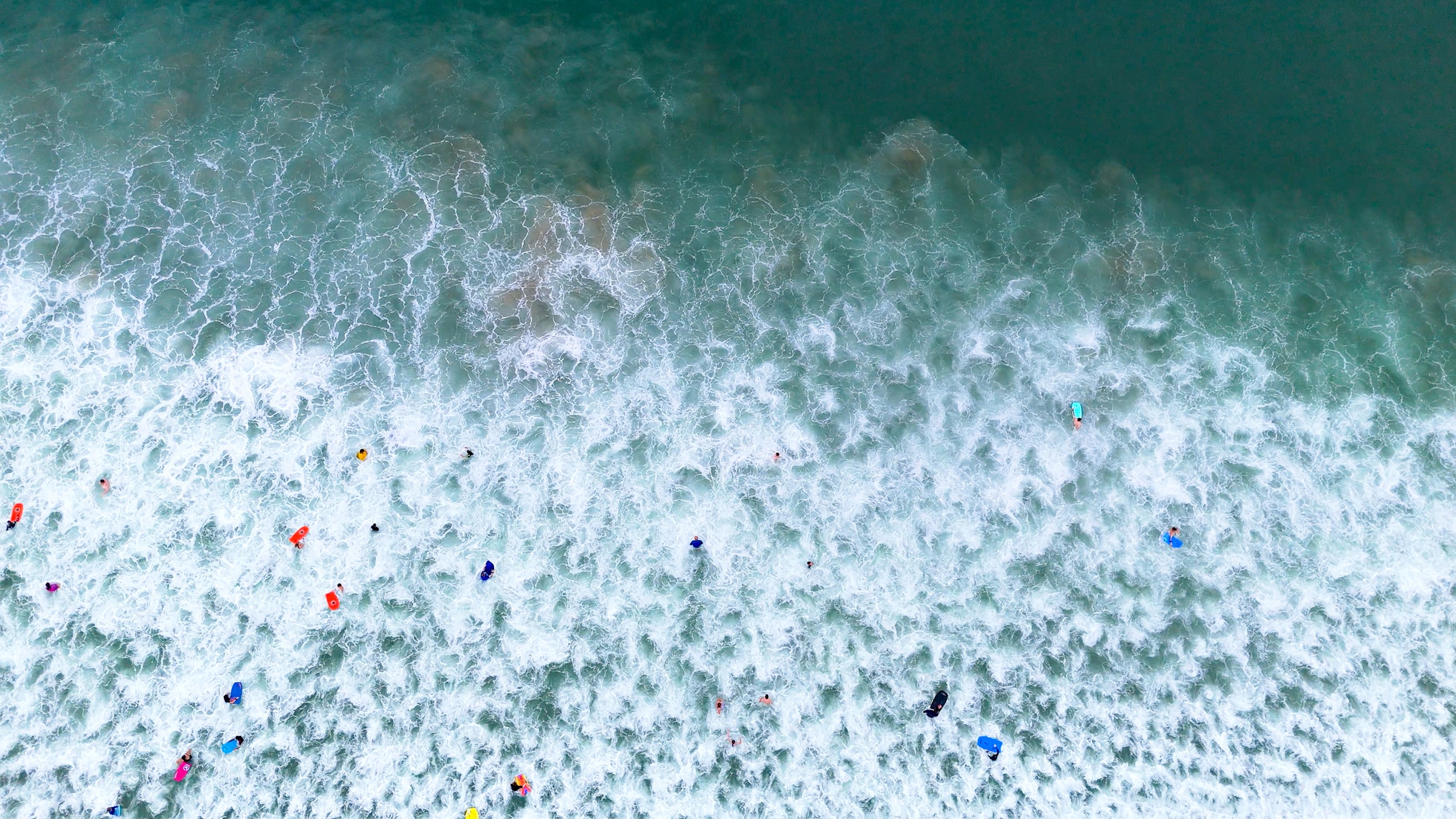 An aerial drone shot of the beach, with lots of people in the sea. Photo: RNLI/Richard Adams.