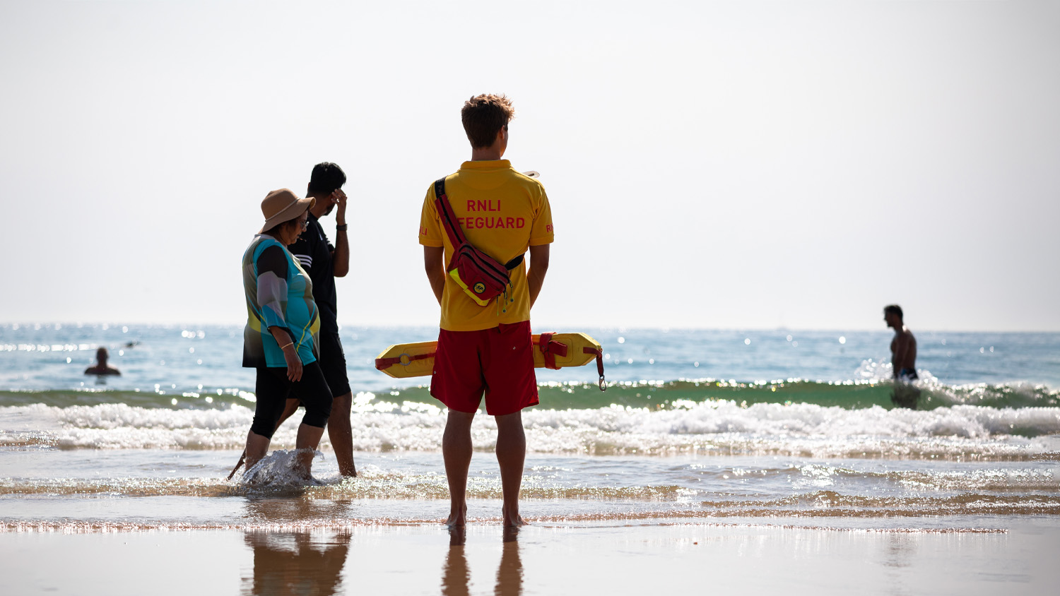 A lifeguard watching people paddling in the sea