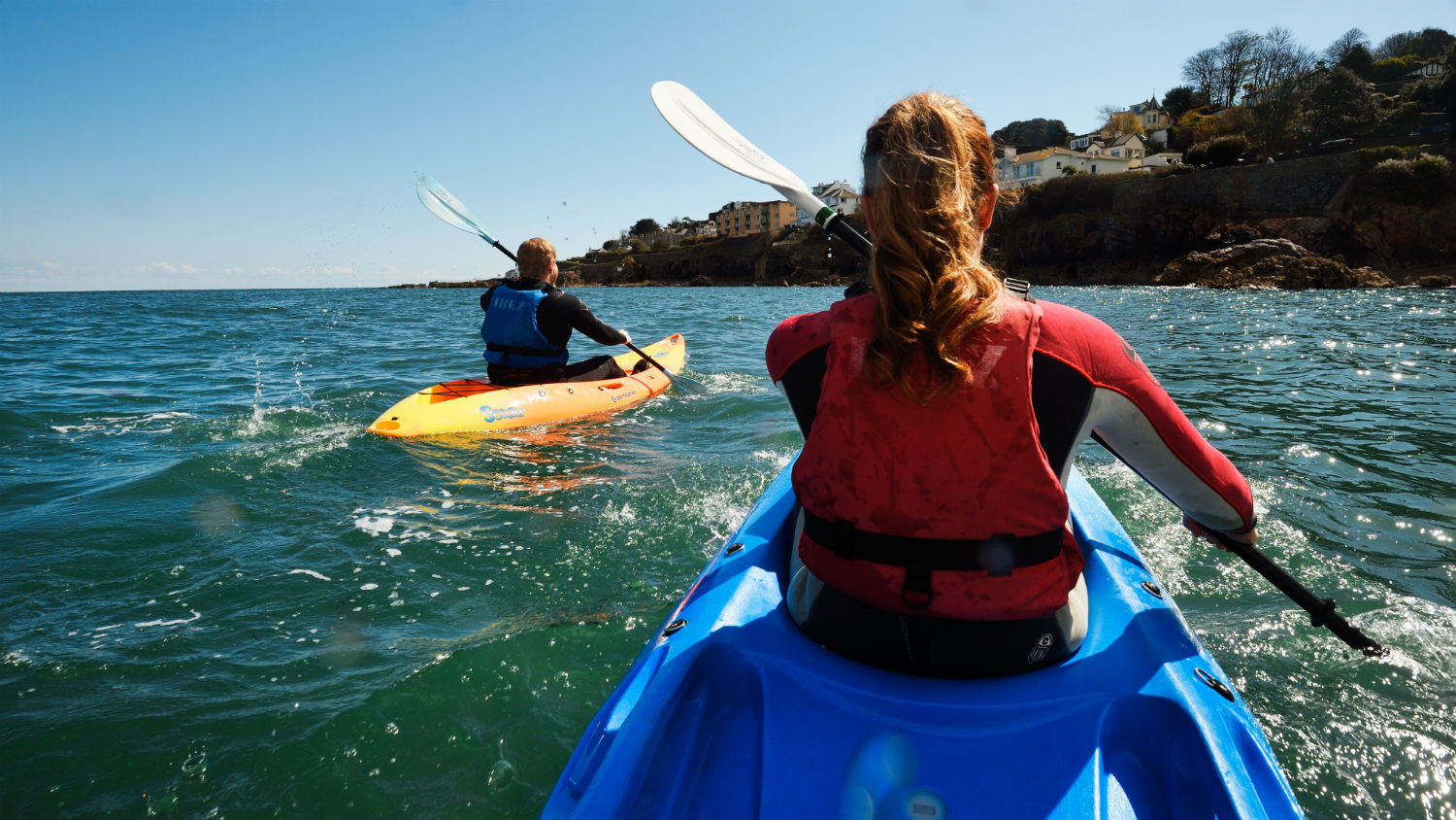 Kayakers paddling at sea