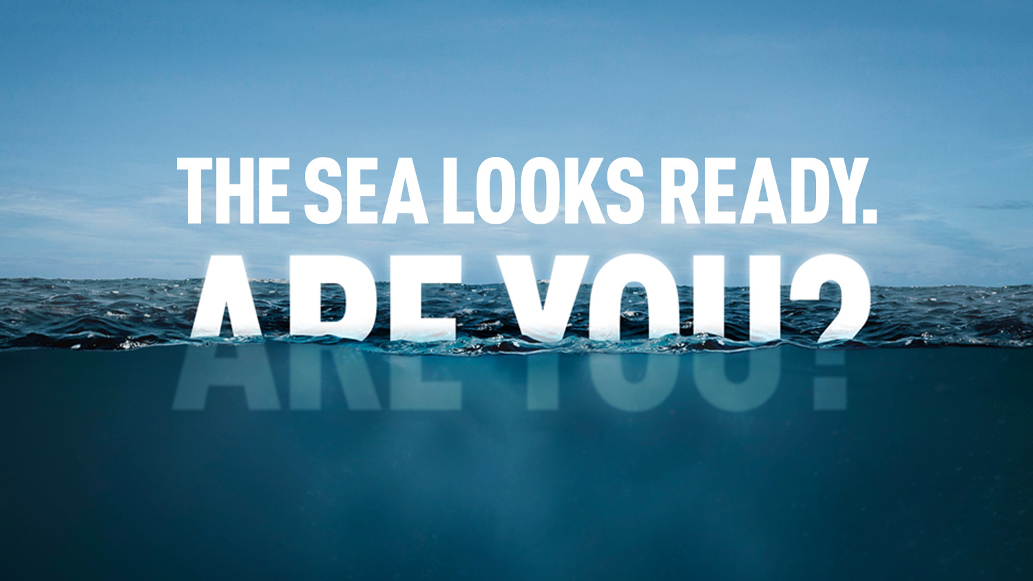 The words The Sea Looks Ready partially submerged in cold blue sea water