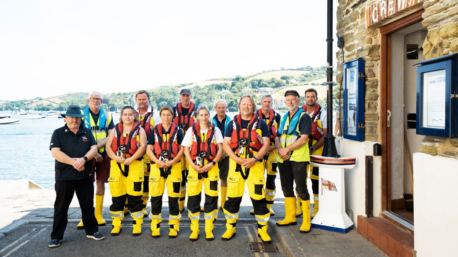 The crew from Salcombe Lifeboat Station standing by the water. Credit: RNLI/Nigel Millard