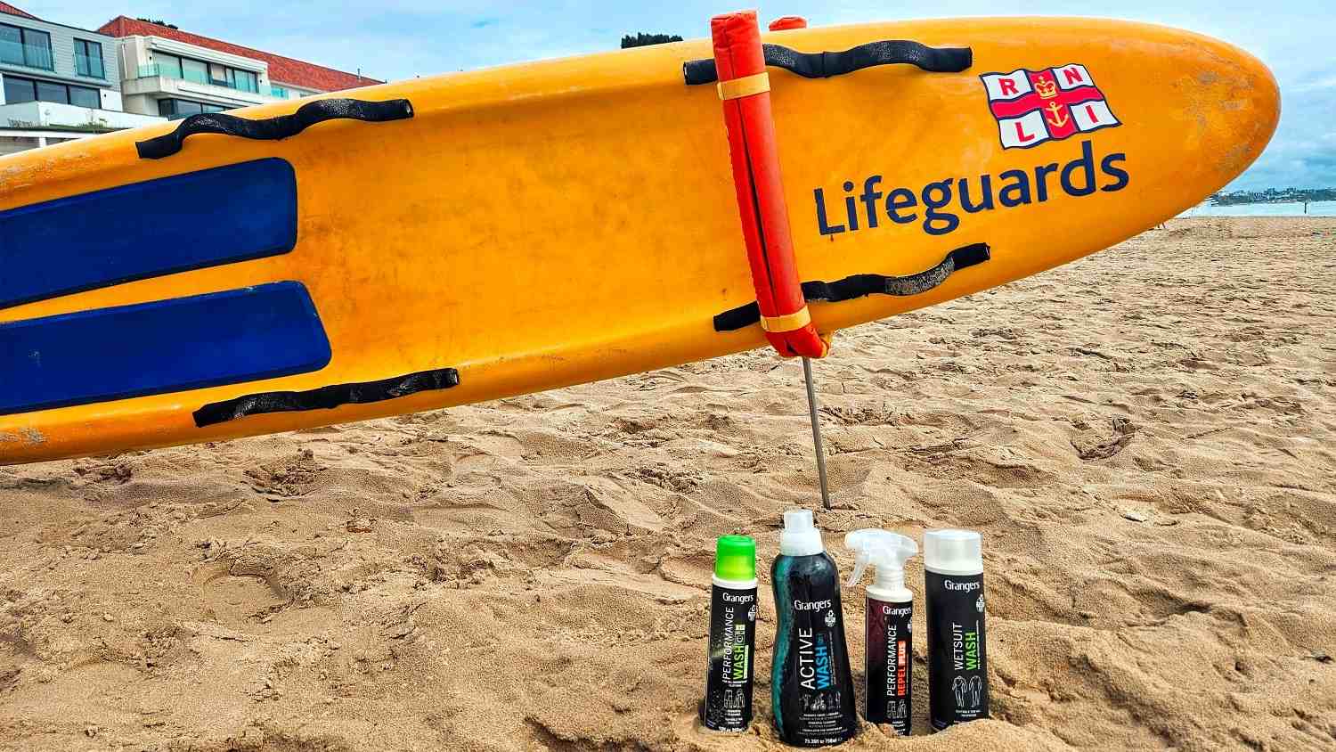 Grangers International products on a beach in front of an RNLI rescue board.