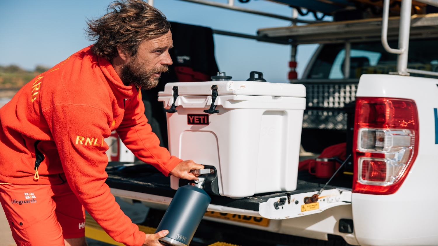 Lifeguard filling up a water bottle from a Yeti cooler