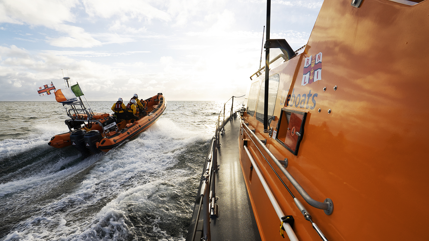 Clifden lifeboats side by side, passing through gentle sea water.