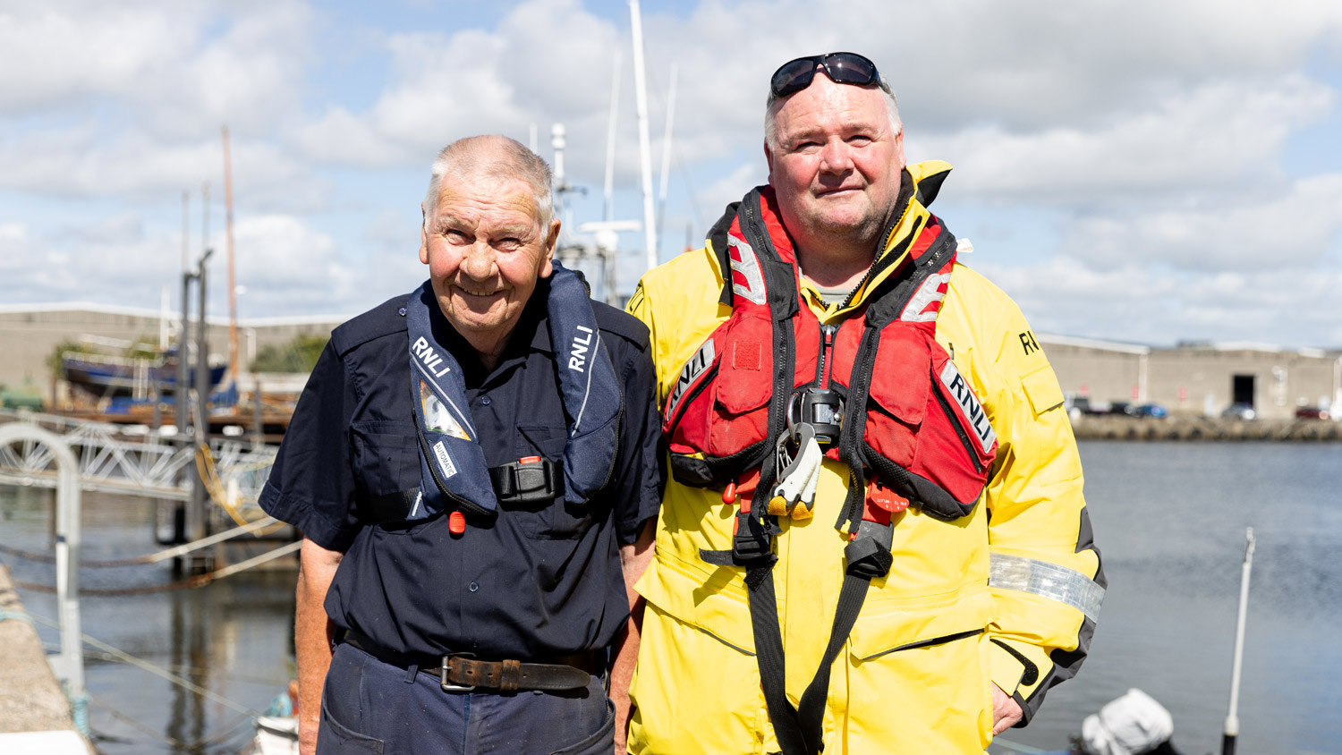 Arklow lifeboat volunteer Christy Gaffney stands next to his son Austin, who is dressed in all-weather lifeboat kit and lifejacket, on the pier next to Arklow harbour
