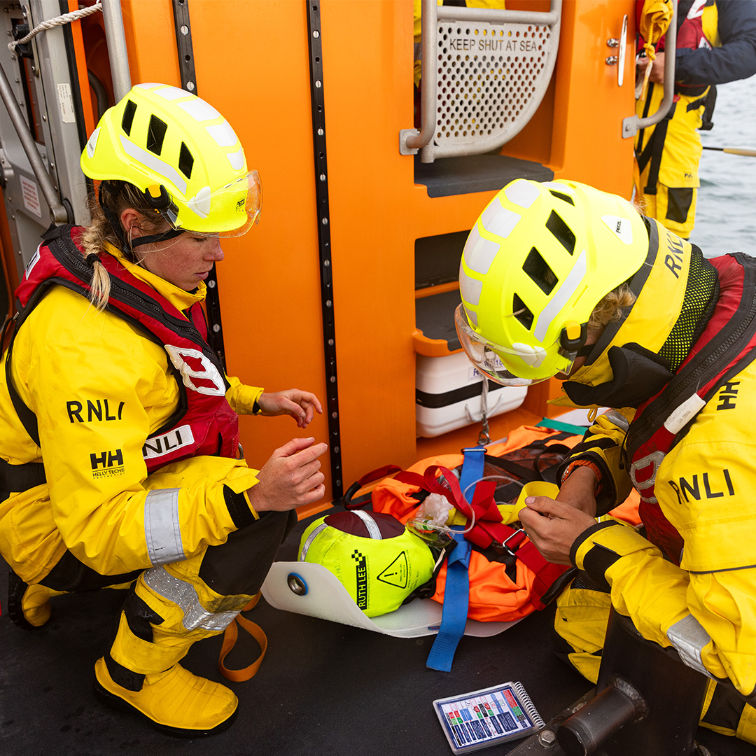 RNLI crew training a new crew member to deal with emergencies at sea