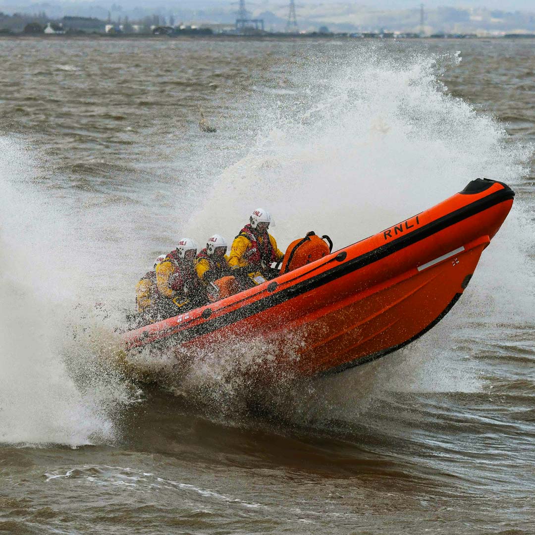 Whitstable's B class lifeboat flies from the crest of a wave as it navigates grey stormy seas