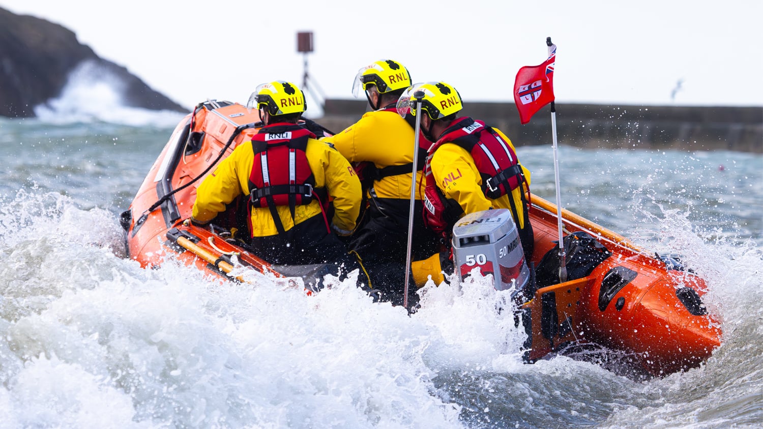 Port Isaac RNLI crew members at sea in their D class lifeboat Pride of Port Isaac (Goeth Porthusek)