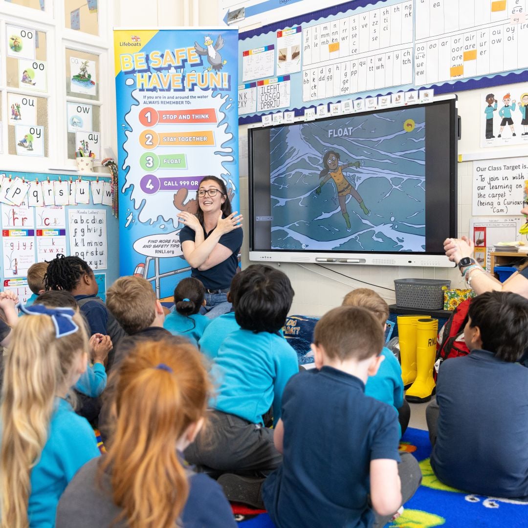 RNLI volunteers doing a water safety presentation for a group of infant school children.