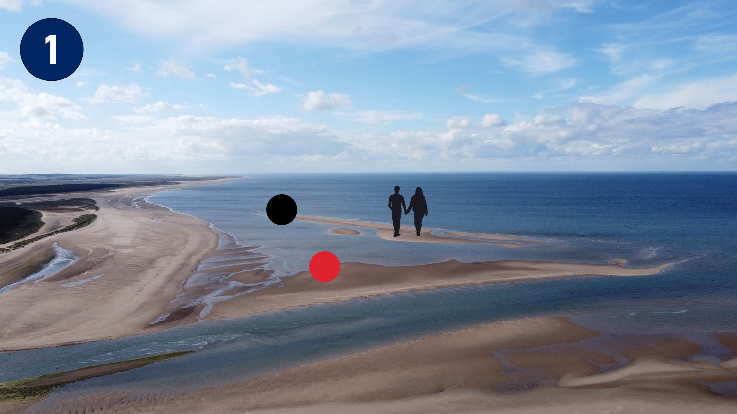 A birds-eye view of Wells beach at low tide. There is a couple walking on the sandbank that is connected to the shore but a considerable way out.
