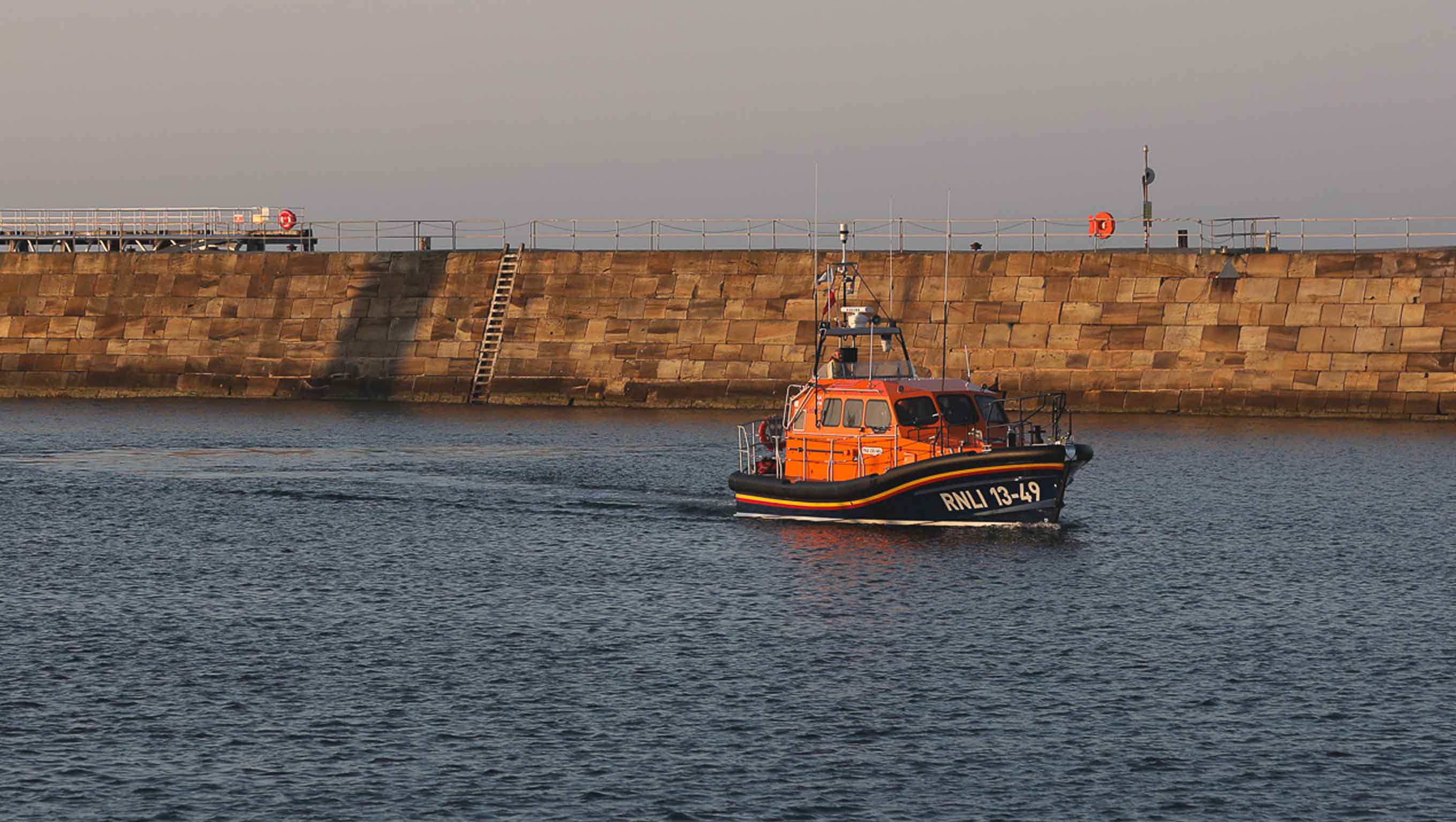 Whitby's Shannon class lifeboat Lois Ivan cruises along the water at sunset