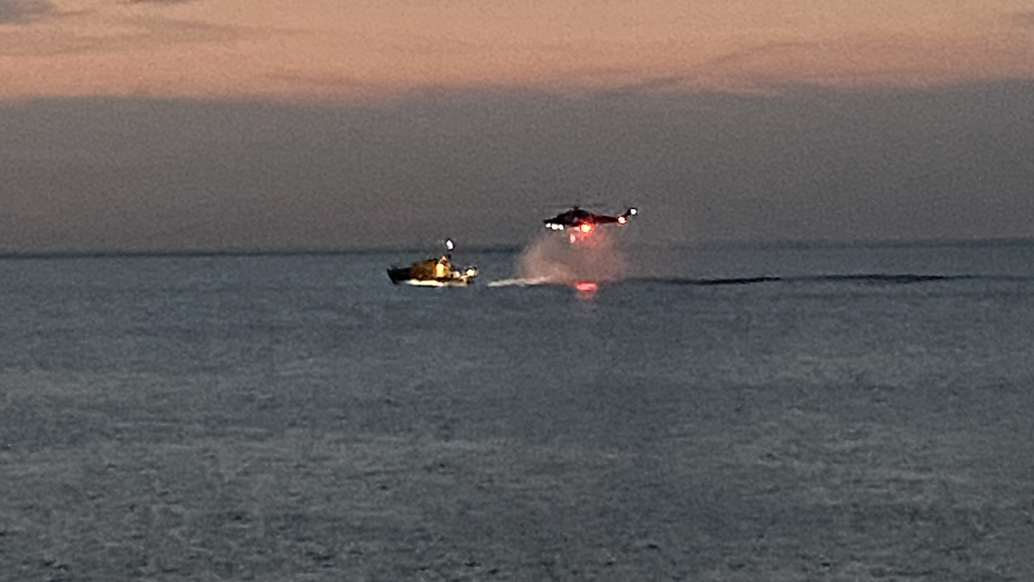 A helicopter flies above Appledore’s all-weather lifeboat, ready to winch an unresponsive swimmer