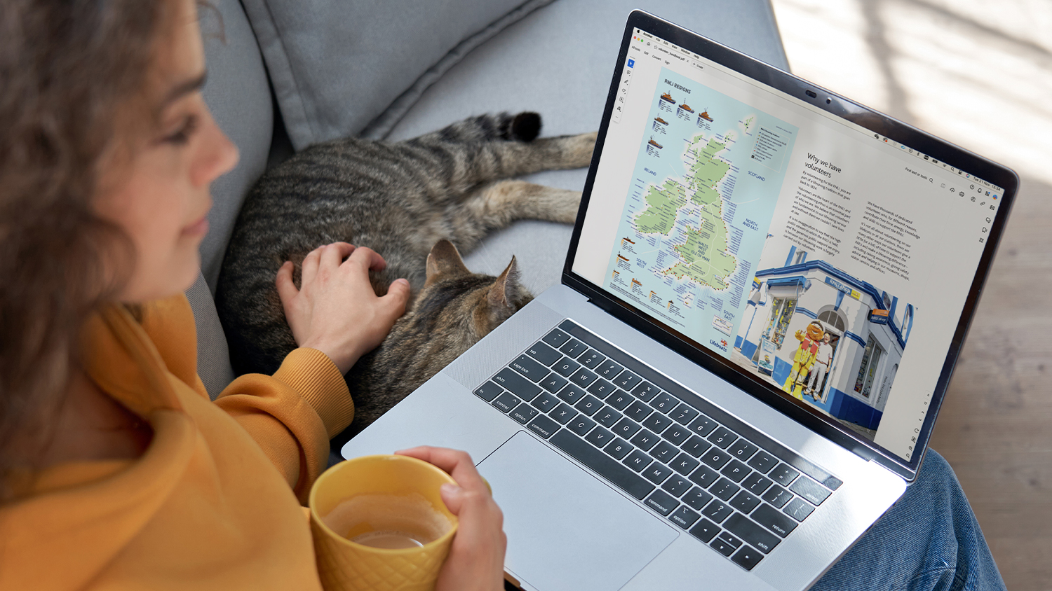 A person sat down using a laptop looking at induction pack materials online