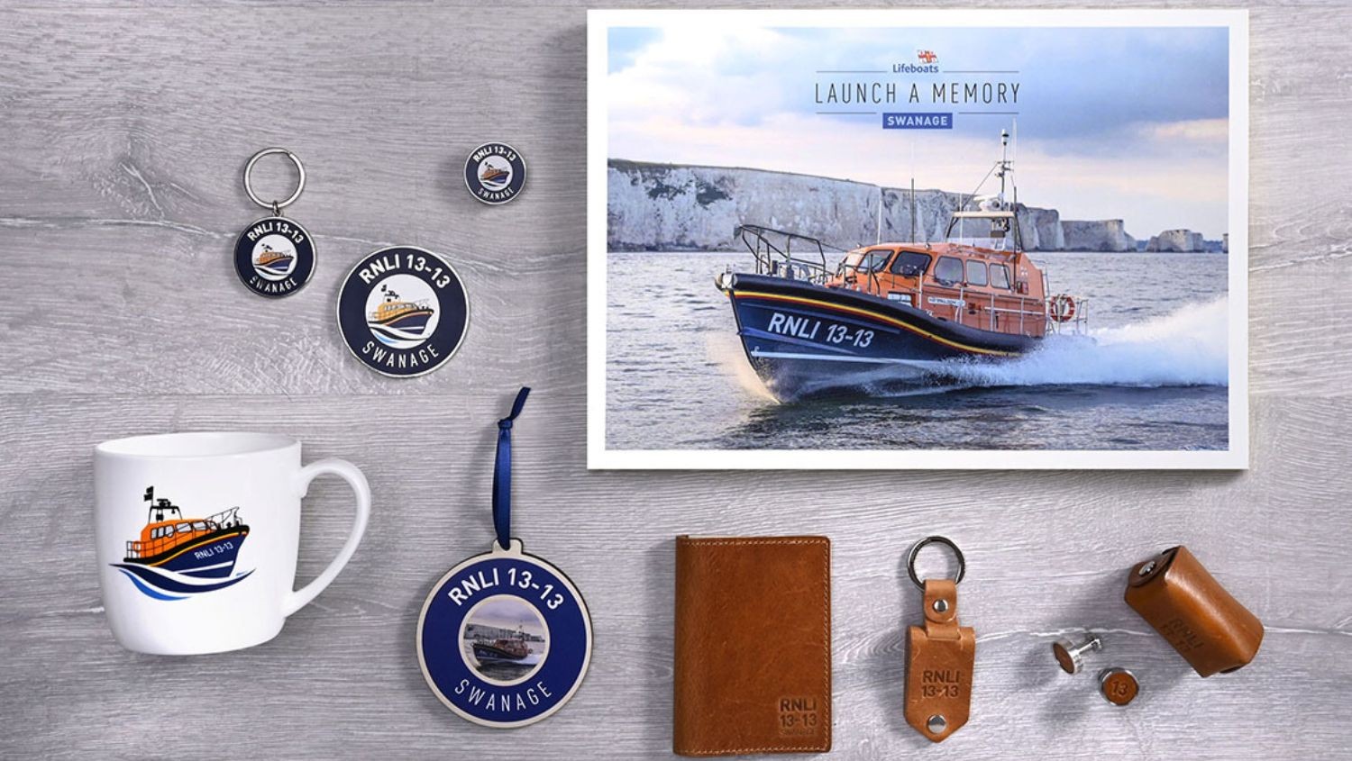 Launch a Memory Swanage collection from RNLI Shop featuring lifeboat-themed keepsakes including mug, keyrings, badges, leather accessories, and framed Shannon class lifeboat print. 