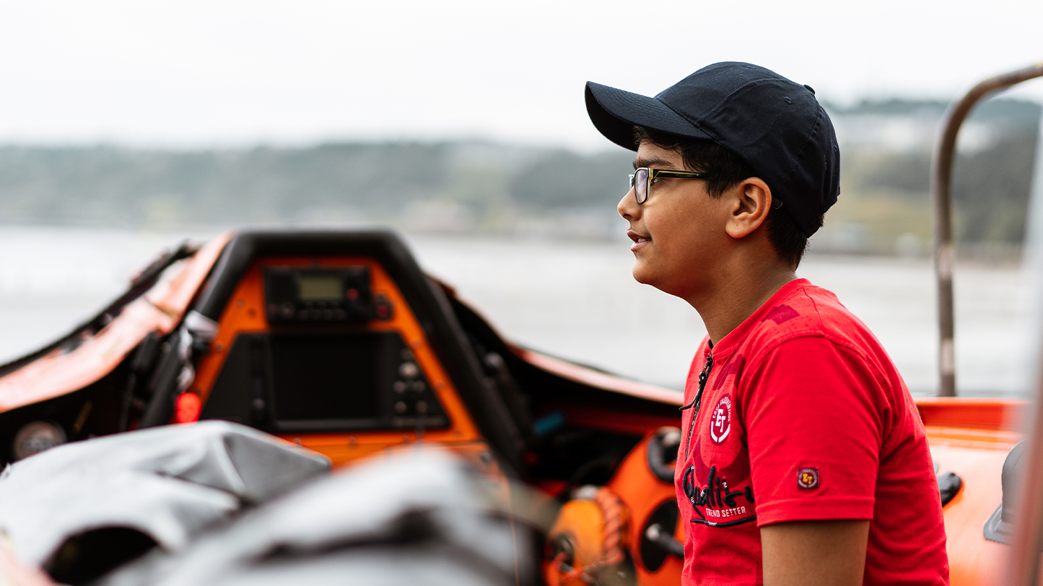 Ravi sits in a lifeboat and looks across the sea on a visit back to Scarborough to thank the lifeboat crew that rescued him