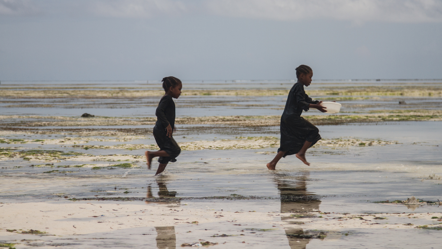 Children playing on the beach at low tide in Zanzibar