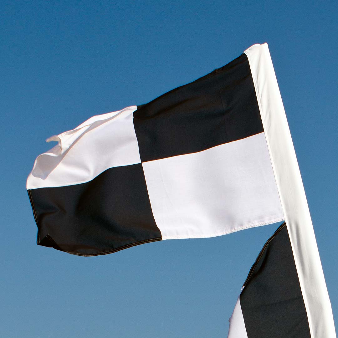 Close up of a black and white beach flag that signals watersports activity in this area