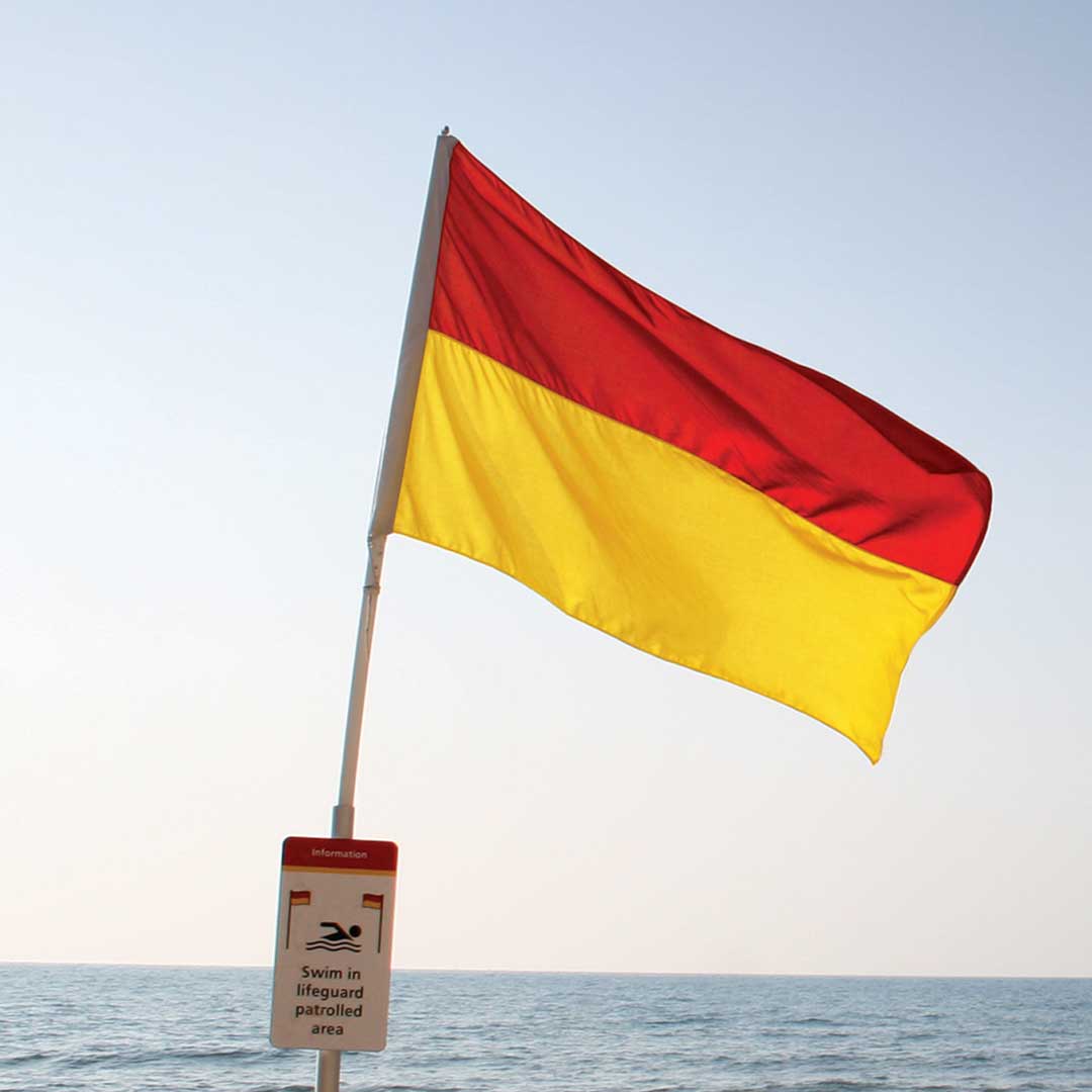 Photo of red and yellow lifeguard flag that signals this beach has a lifeguard patrol.