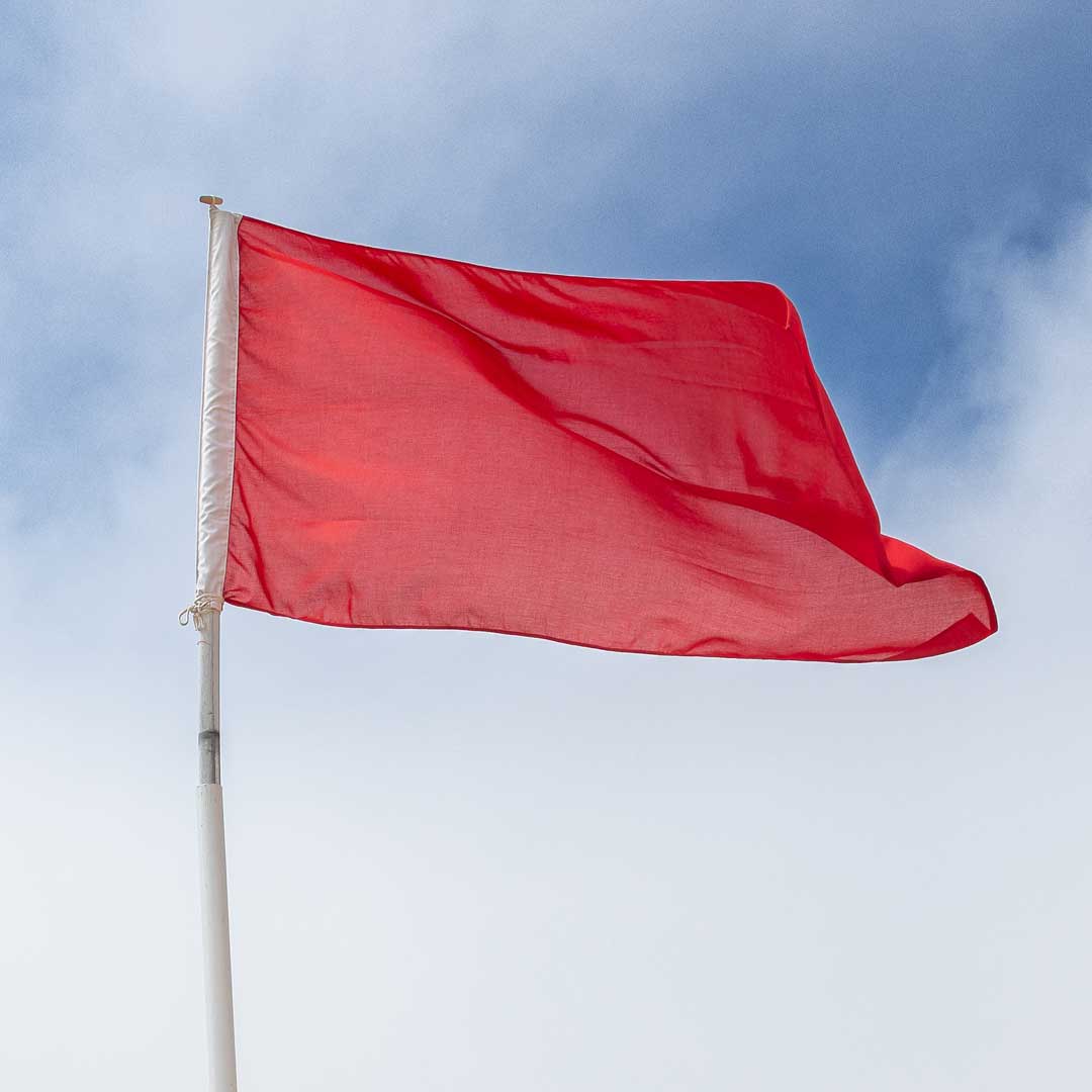 Photo of red beach lifeguard flag that signals the water is unsafe to enter